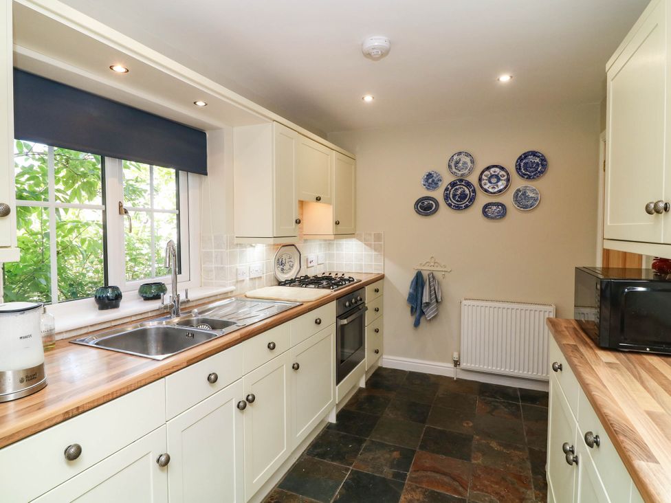 A kitchen with a sink, stove, and cabinets at Wisteria House in Lincoln