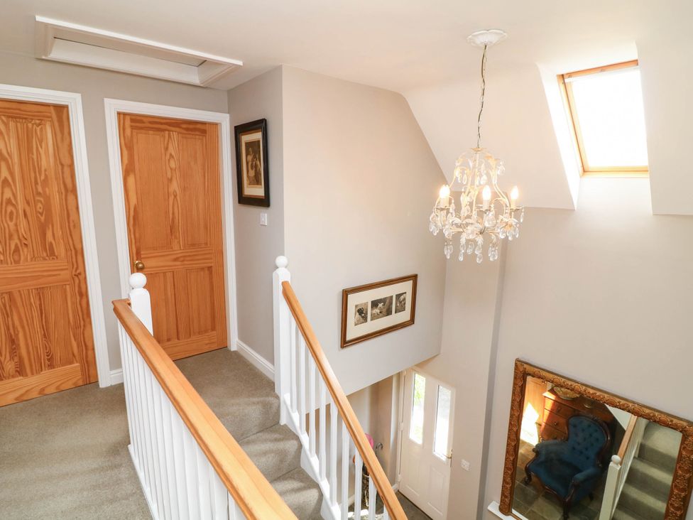 A hallway with a staircase and chandelier at Wisteria House in Lincoln