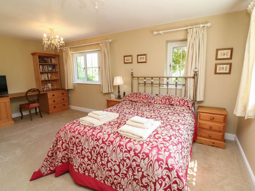 A bedroom with a bed, desk, chair and shelves at Wisteria House in Lincoln