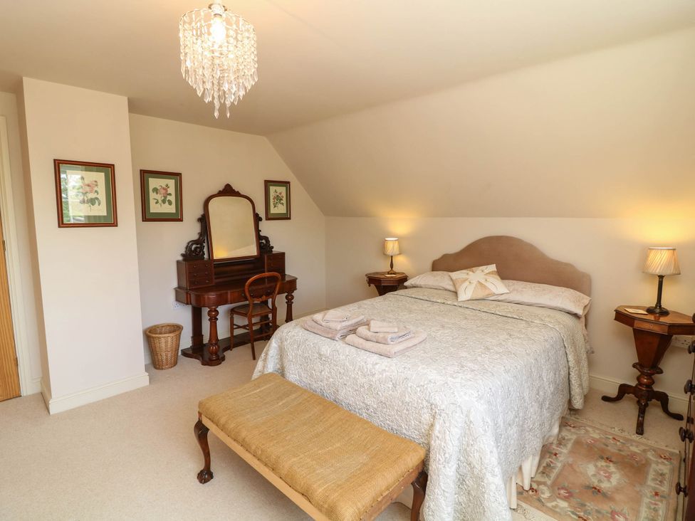A bedroom with a bed and dressing table at Wisteria House in Lincoln