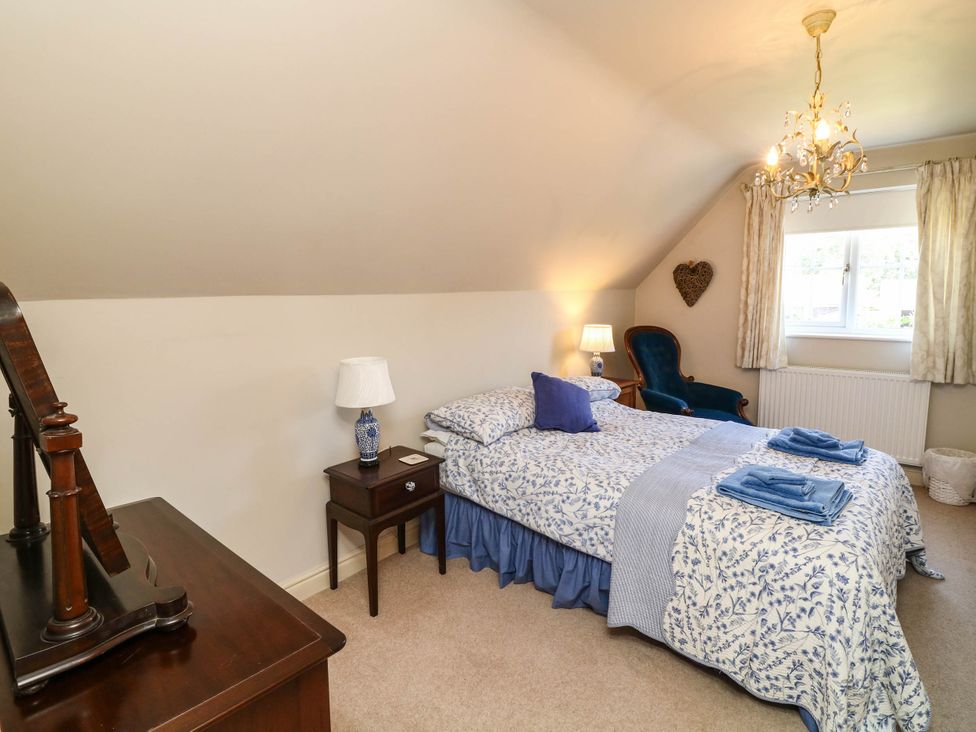 A bedroom with a bed and a chair at Wisteria House in Lincoln