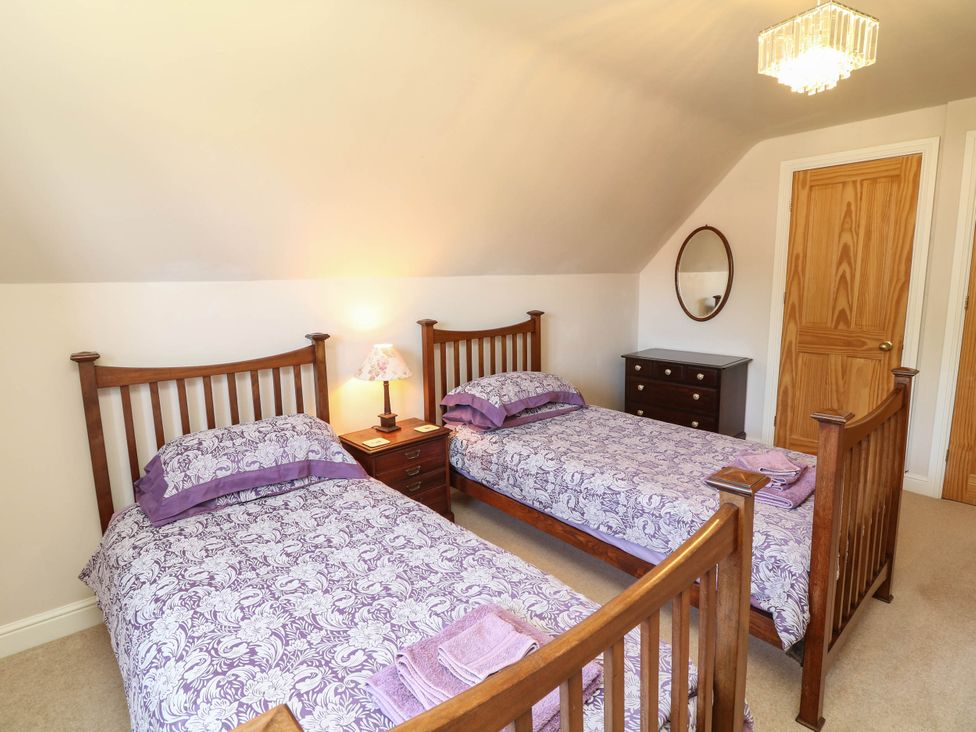 A bedroom with two beds and a nightstand at Wisteria House in Lincoln