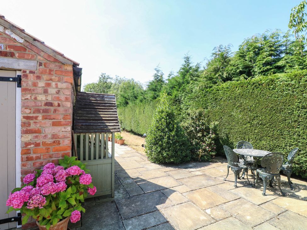 A garden with a stone patio and table with chairs at Wisteria House in Lincoln