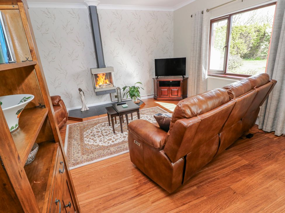 A living room with a fireplace and a sofa at Harvest Hill in Letterston