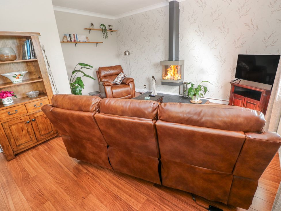 A living room with a fireplace and sofa at Harvest Hill in Letterston