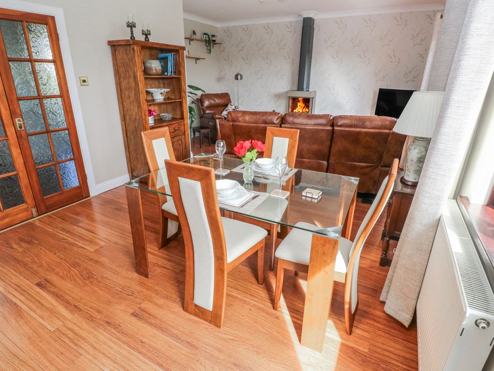 A dining room with a glass table and chairs at Harvest Hill in Letterston