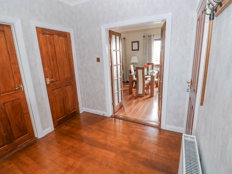 A hallway with doors and access to the dining area at Harvest Hill in Letterston