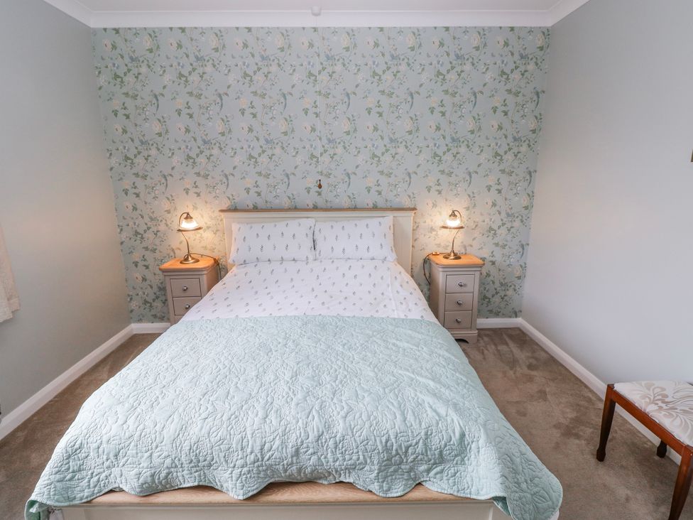 A bedroom with a bed and nightstand at Harvest Hill in Letterston