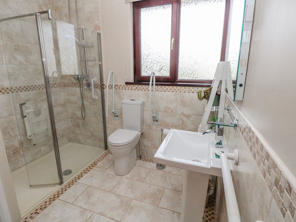 A bathroom with a shower, toilet, and sink at Harvest Hill in Letterston