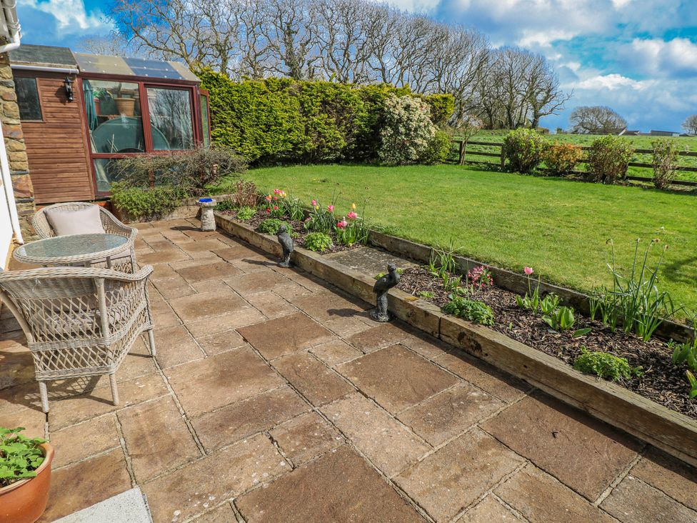 A garden with outdoor seating and flower bed at Harvest Hill in Letterston