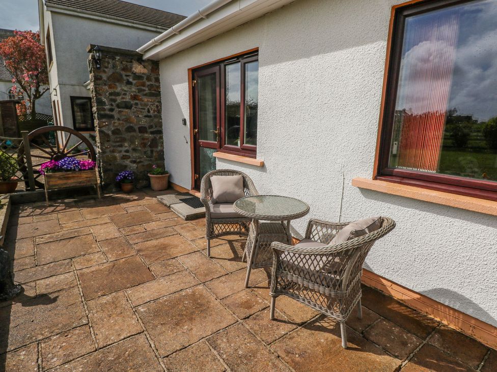 An outdoor seating area with a table and chairs at Harvest Hill in Letterston