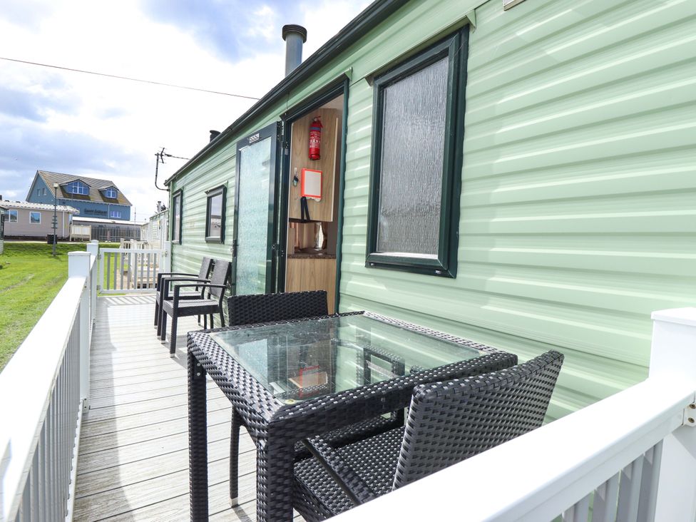 An outdoor area with chairs and a table at The Seafront Cosy Caravan in Ingoldmells