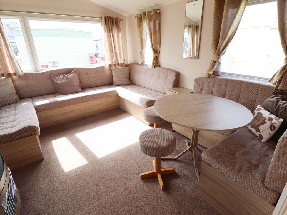 A living room with a round table and sofa at The Seafront Cosy Caravan Ingoldmells