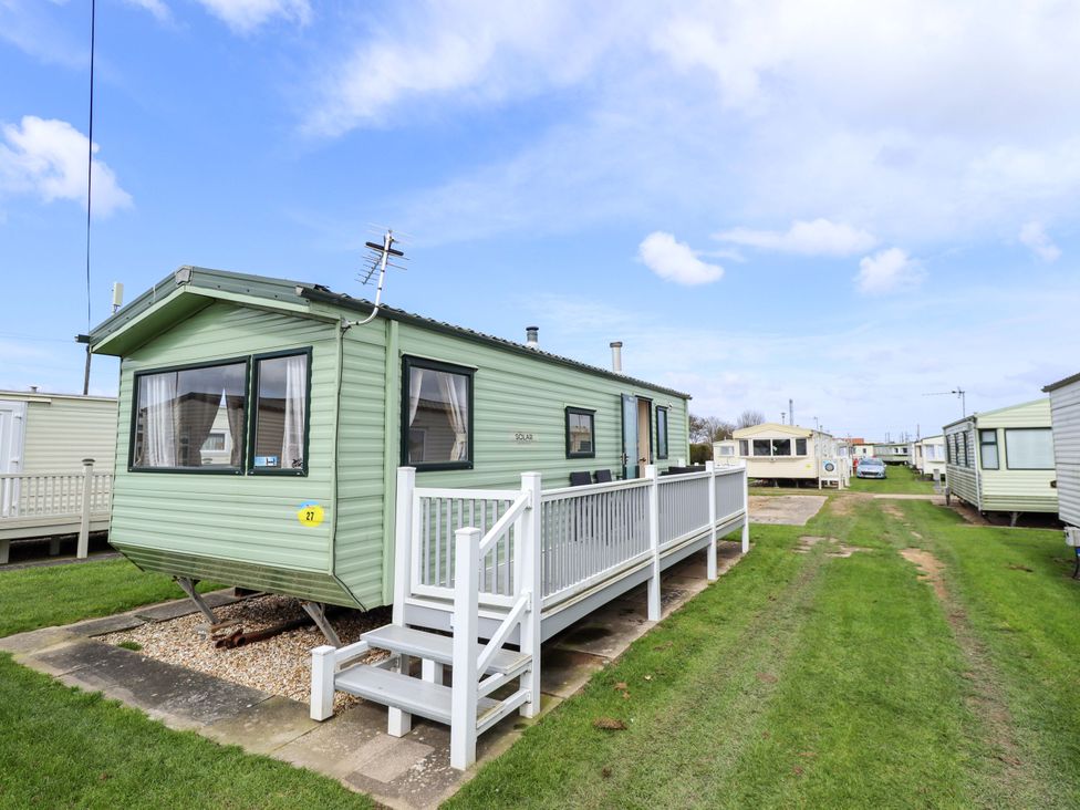 A green caravan with steps and a handrail at The Seafront Cosy Caravan in Ingoldmells