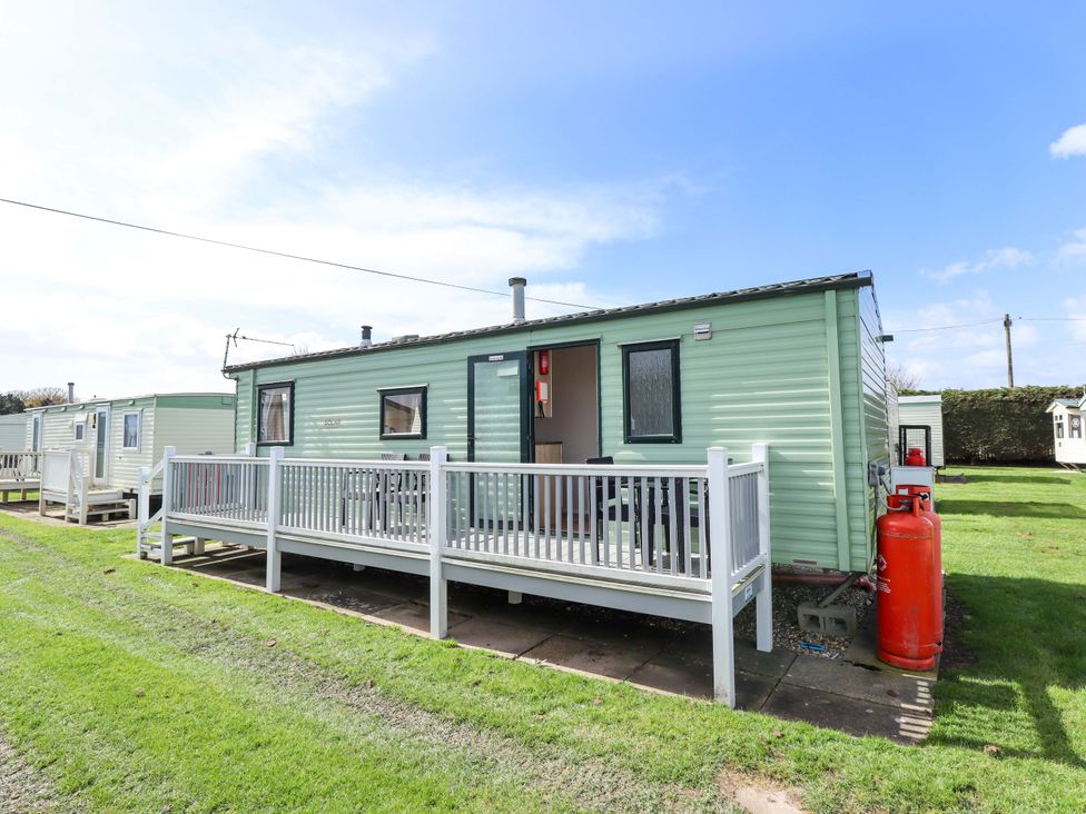 A caravan with a deck in front at The Seafront Cosy Caravan in Ingoldmells
