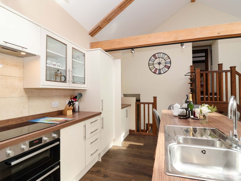 A kitchen with cabinets and a sink at Cider Press Cottage Torpoint