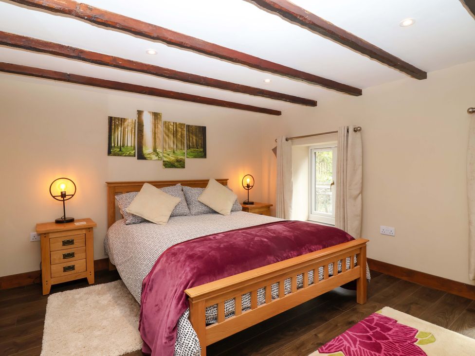 A bedroom with a bed and bedside table at Cider Press Cottage in Torpoint