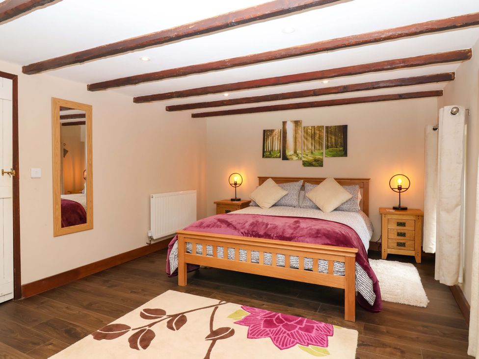 A bedroom with a bed and bedside tables at Cider Press Cottage in Torpoint