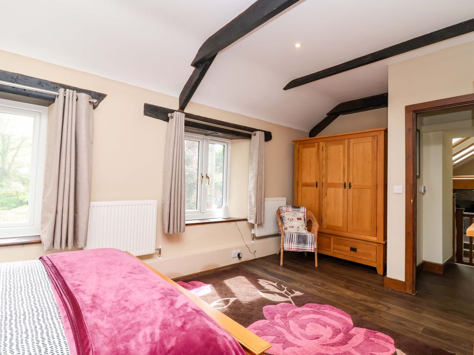 A bedroom with a bed and wardrobe at Cider Press Cottage in Torpoint