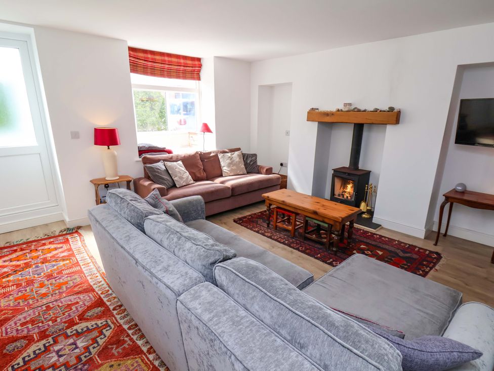 A living room with a fireplace and two sofas at Cozy Cottage