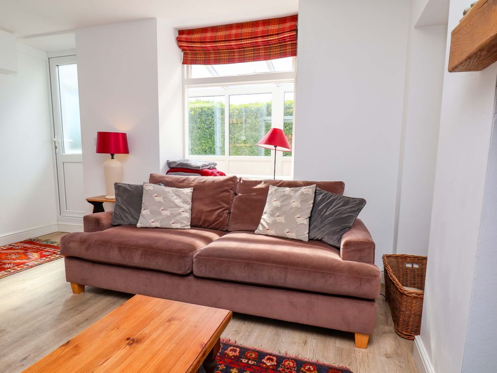 A living room with a sofa and table at Cozy Cottage