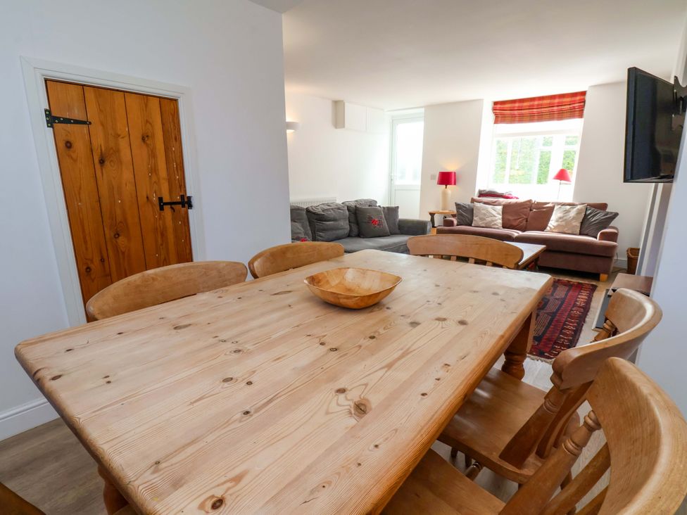 A dining room with a wooden table and chairs at Cozy Cottage