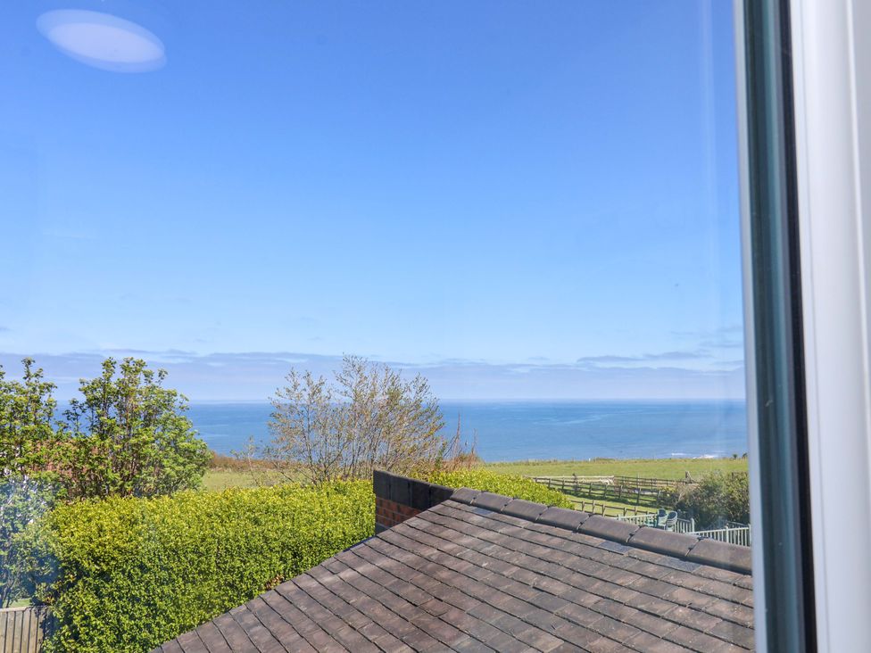 A view of the ocean and greenery from a building at Cozy Cottage