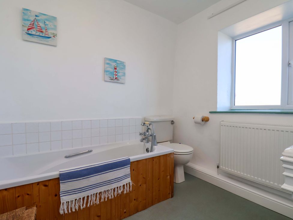 A bathroom with a bathtub and toilet at Cozy Cottage in 