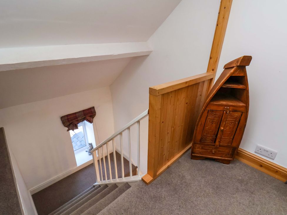 A staircase with a window and wooden cabinet at Cozy Cottage
