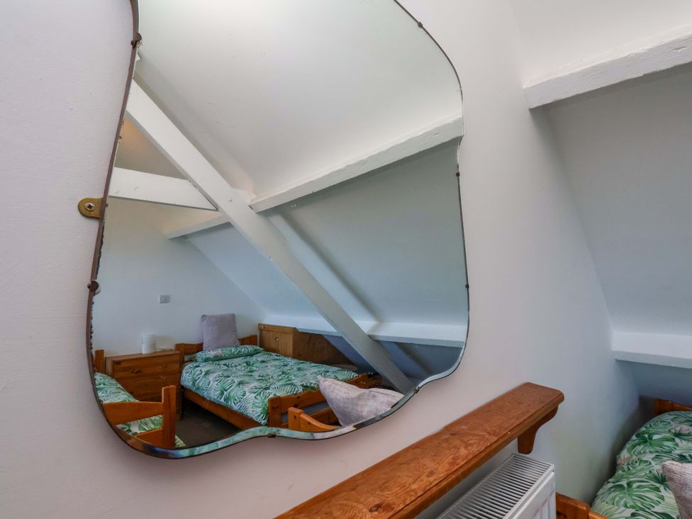 A bedroom with a mirror and bed at Cozy Cottage