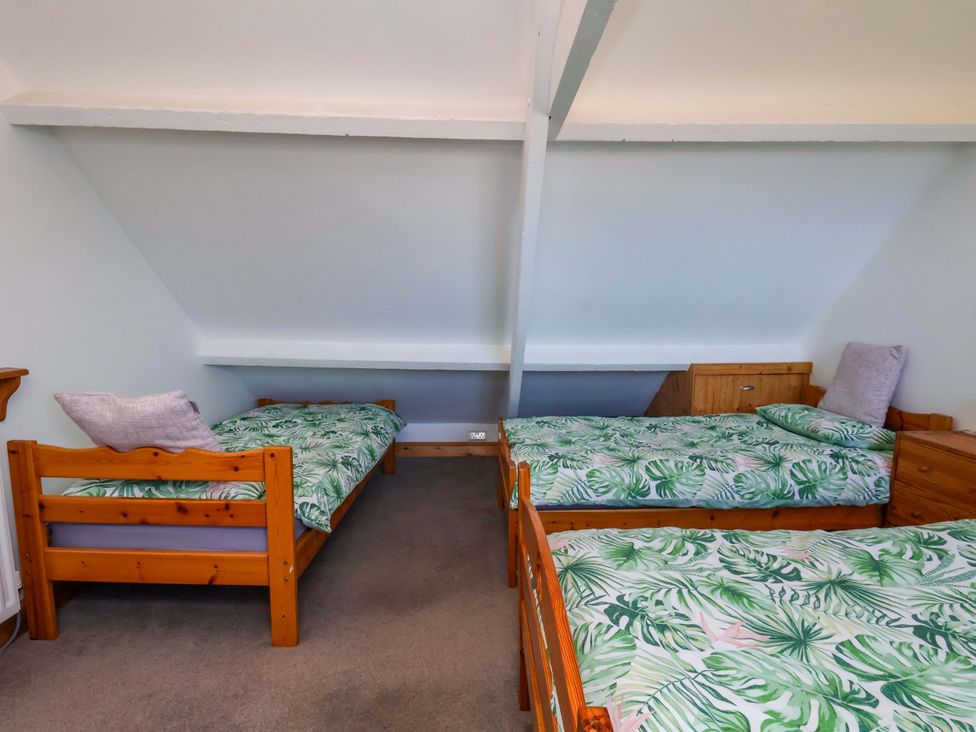 A bedroom with two beds and a bedside table at Cozy Cottage
