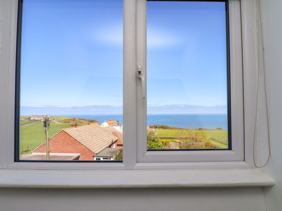 A view of ocean and landscape from a window at Cozy Cottage in 