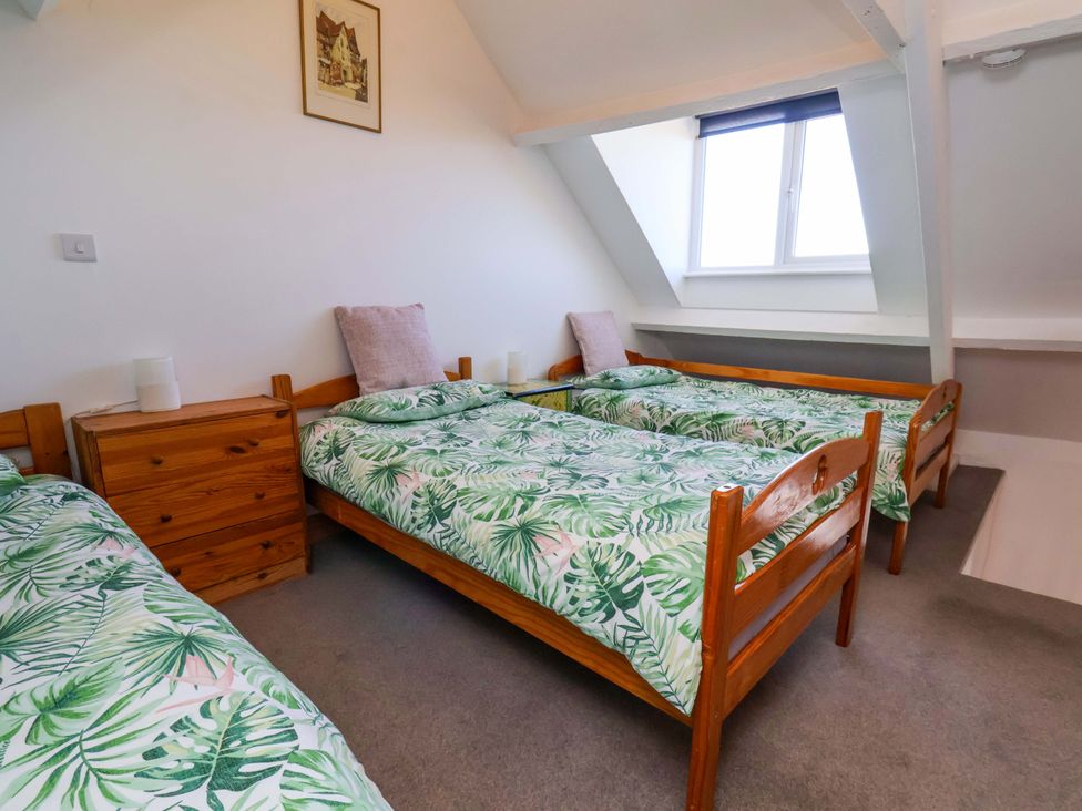 A bedroom with two beds and a window at Cozy Cottage