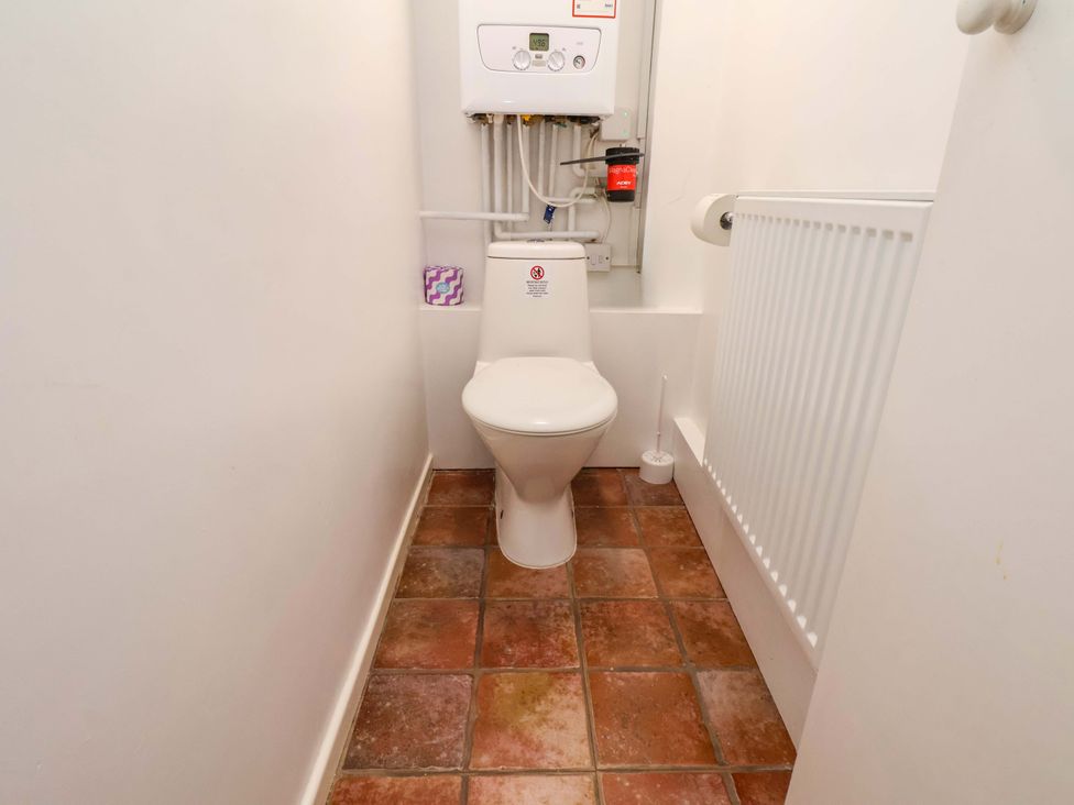 A bathroom with a toilet and radiator at Cozy Cottage