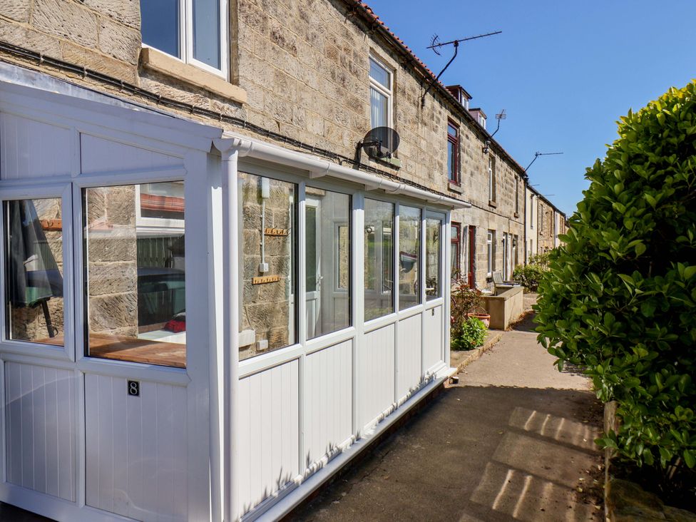 An outdoor view of a building with windows and a pathway at Cozy Cottage