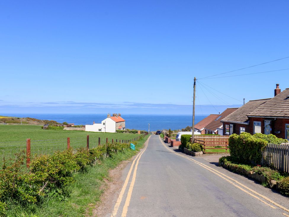 A road leading to houses with ocean view at Cozy Cottage