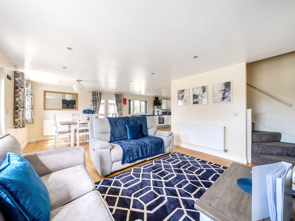 A living room with a sofa and dining area at Lodge 4 Near Brigg