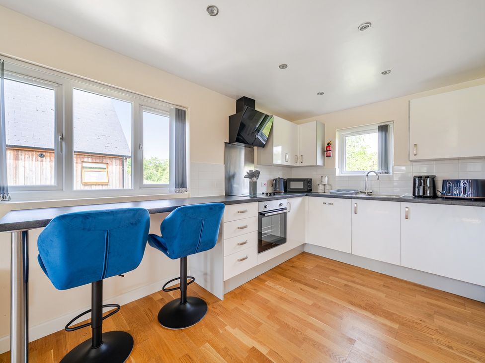 A kitchen with bar stools and appliances at Lodge 4 near Brigg