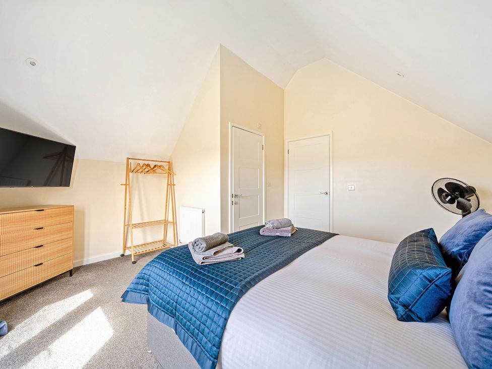 A bedroom with a bed and television at Lodge 4 Near Brigg