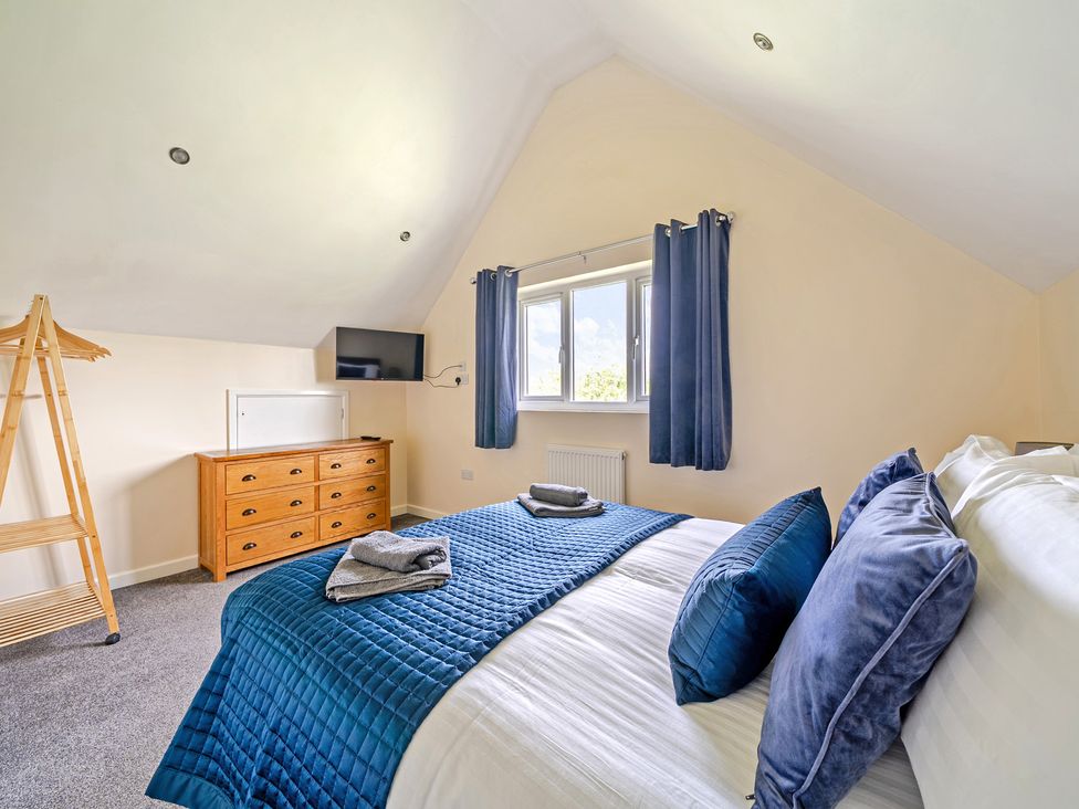 A bedroom with a bed and dresser at Lodge 4 Near Brigg
