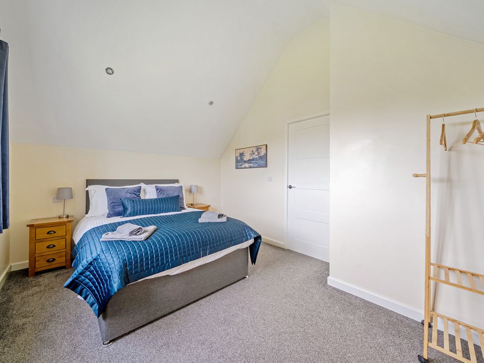 A bedroom with a bed and nightstand at Lodge 4 near Brigg