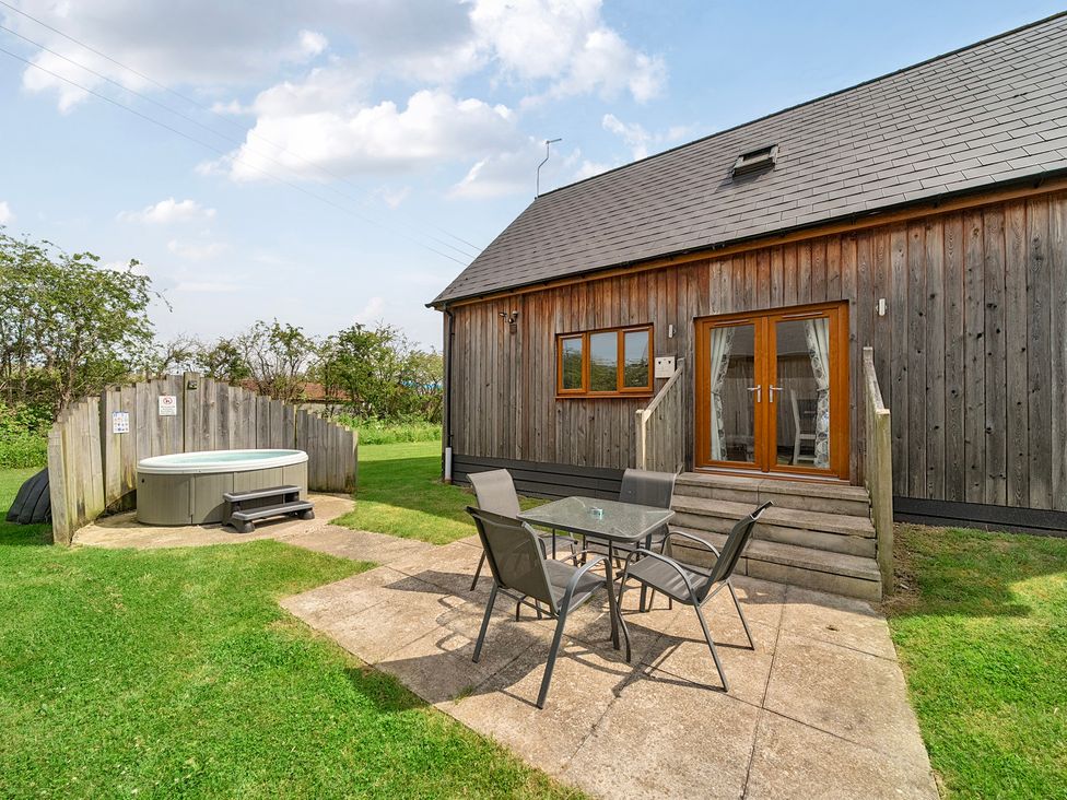 An outdoor area with a hot tub and a seating arrangement at Lodge 4 Near Brigg
