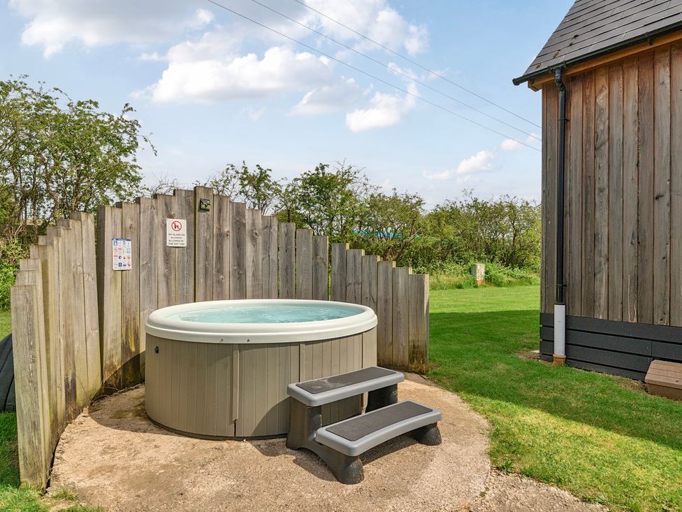 An outdoor area with a hot tub and stool at Lodge 4 Near Brigg