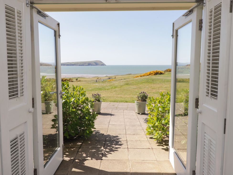 A view from an open door showcasing the sea and greenery at The Bolthole in Newport