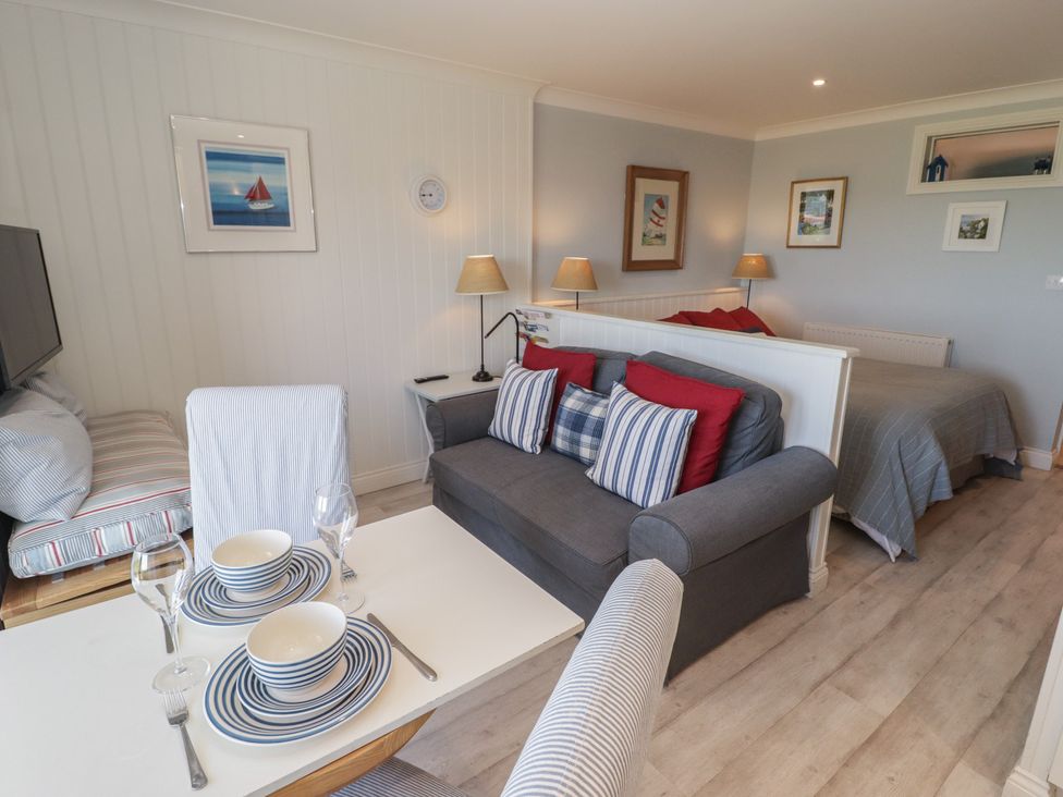 A living room with a sofa and dining table at The Bolthole in Newport