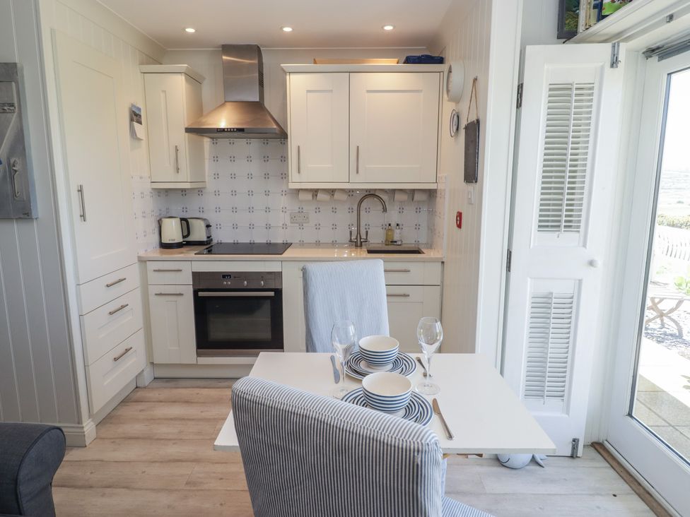 A kitchen with a dining table and chairs at The Bolthole in Newport