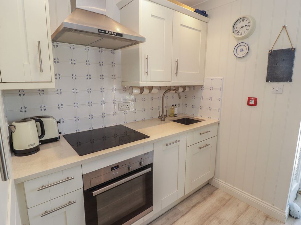 A kitchen with a sink, cooker, and kettle at The Bolthole in Newport