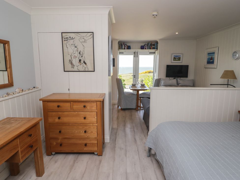 A studio with bed, dresser, and table at The Bolthole in Newport