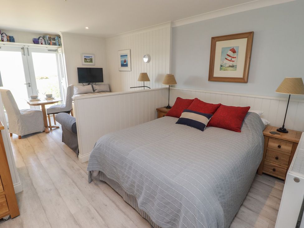 A bedroom with a bed, seating area and table at The Bolthole in Newport