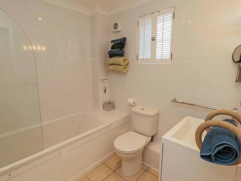 A bathroom with a bathtub toilet sink and towels at The Bolthole in Newport